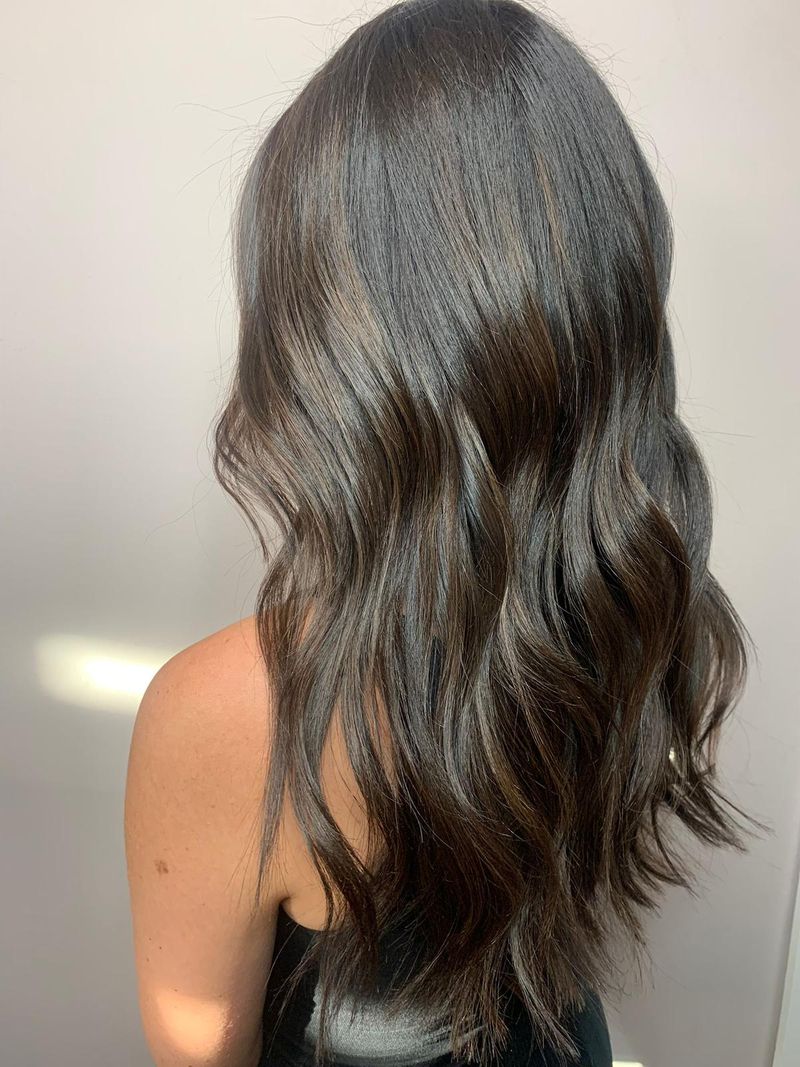 Woman with shiny, long brunette hair after hair glossing